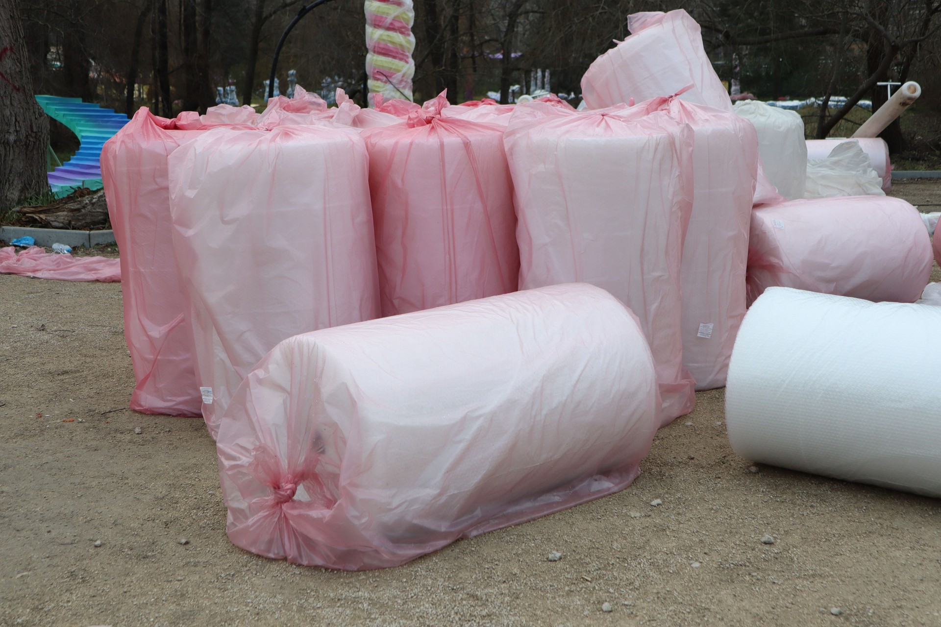 Varieties of Rolled Materials Adorned and Wrapped in Bright Pink Plastic Sheeting for Protection